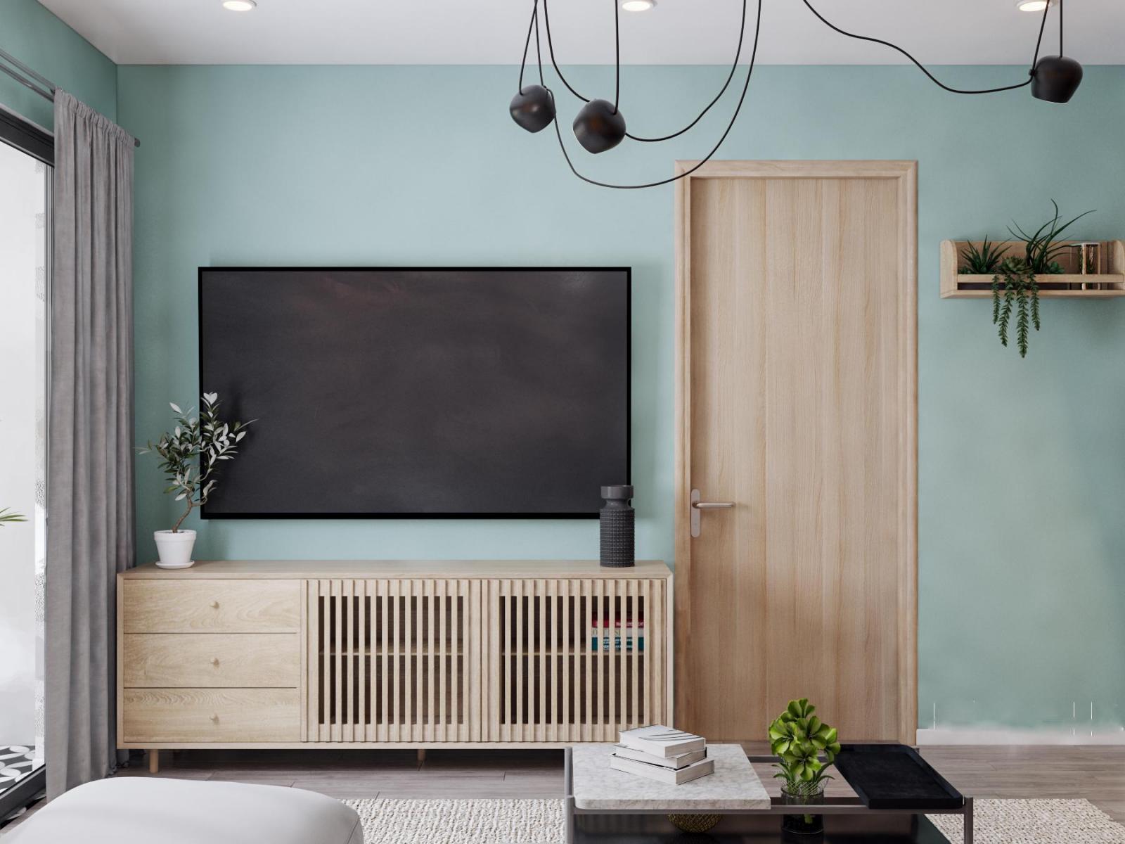 Góc phòng khách căn hộ 90m2 với tường màu xanh pastel nhã nhặn, làm nền cho nội thất gỗ màu sáng trở nên nổi bật hơn.