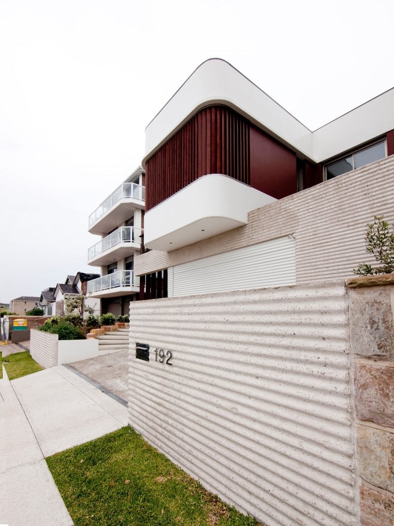 cận cảnh mặt bên ngôi nhà 3 tầng Growing House ở Úc với tường ốp các tấm lợp tôn, gara ở tầng trệt