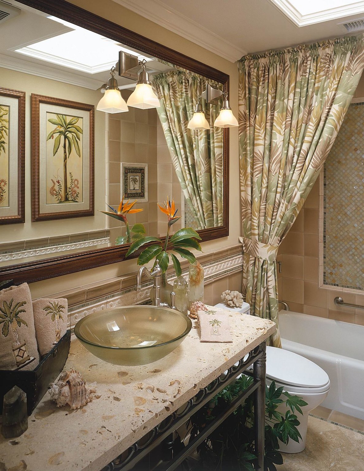 Một phòng tắm phong cách nhiệt đới đầy hoa văn màu xanh lá cây kết hợp ăn ý với bộ đèn treo tường xinh xắn.