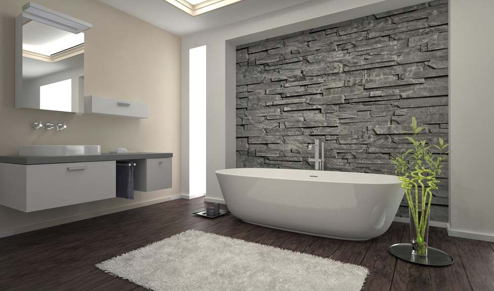 phòng tắm màu trung tính với bồn tắm màu trắng, tường đá điểm nhấn