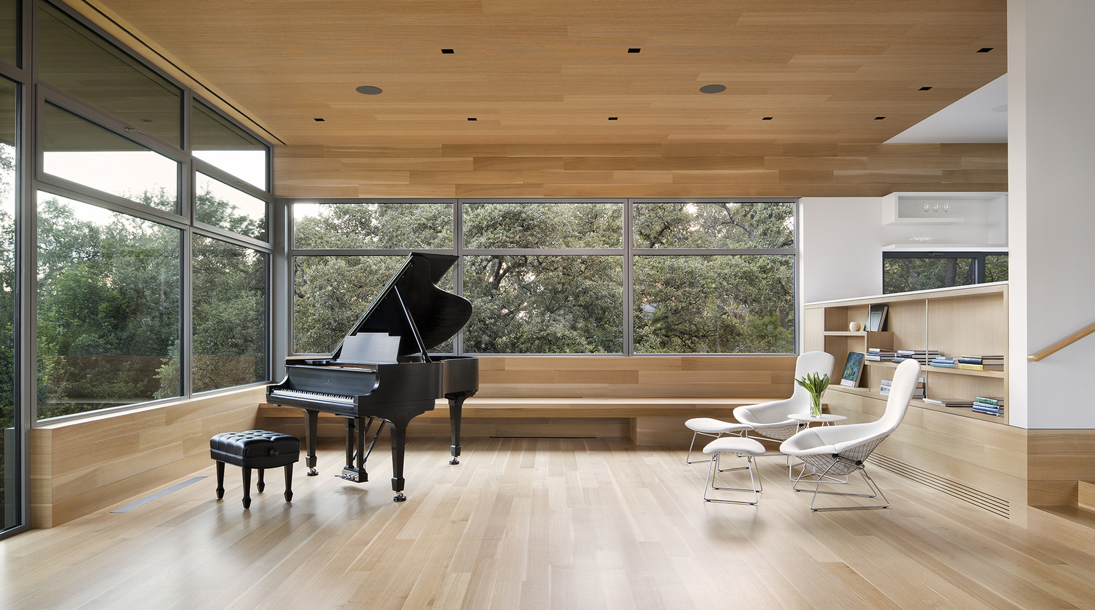 hình ảnh một căn phòng rộng rãi, tường kính, đàn piano, ghế ngồi màu trắng