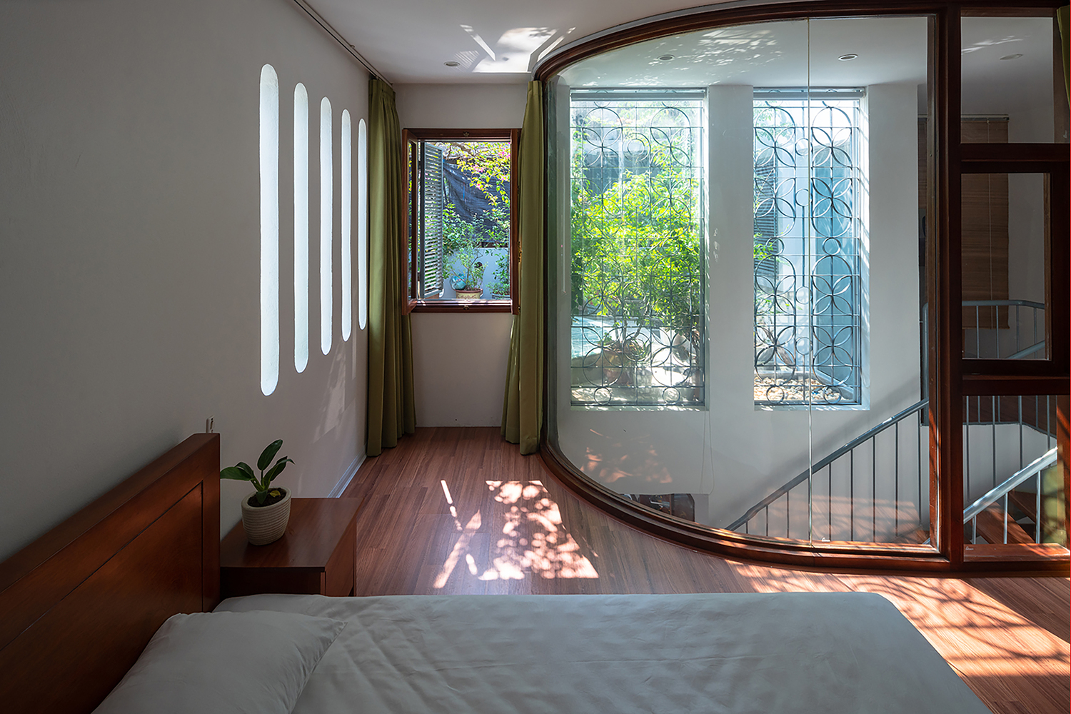 Phòng ngủ trong nhà phố 3 tầng được thiết kế mở ra ban công xanh mát và sân vườn trên sân thượng nên luôn đón được luồng không khí trong lành.