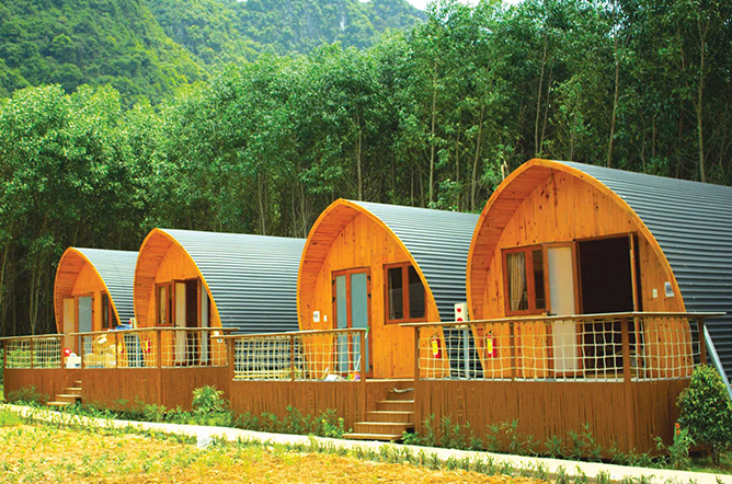 hình ảnh minh họa cho mô hình dự án farmstay với các ngôi nhà gỗ hình vòm màu vàng, xung quanh là rừng núi xanh ngát