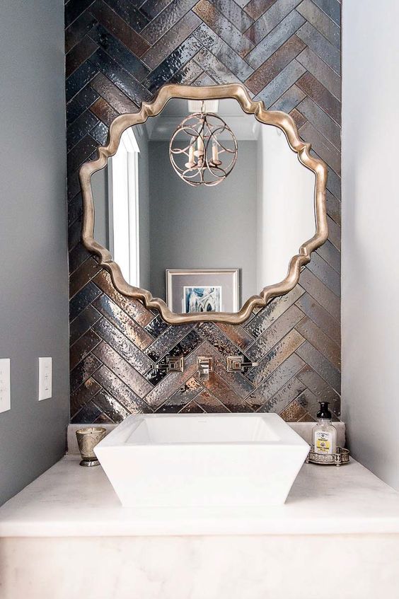 hình ảnh một góc phòng tắm với gạch ánh kim bao quanh khung gương
