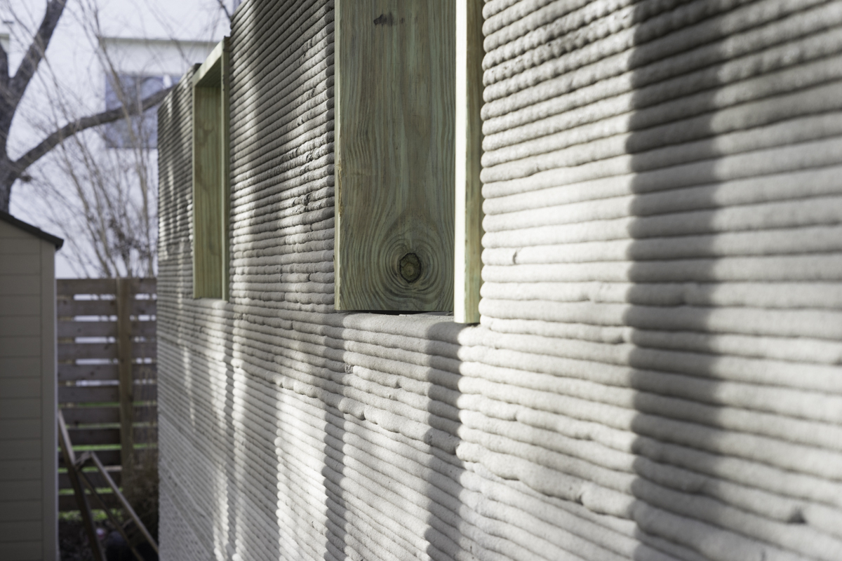 hình ảnh cận cảnh ngôi nhà in 3D với tường ngoài màu trắng xen kẽ gỗ sáng màu