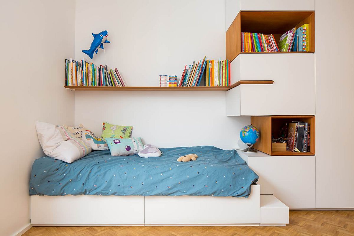 phòng ngủ nhỏ với tông trắng chủ đạo, ga gối màu xanh dương, giá kệ gỗ gắn tường