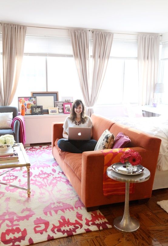Ghế sofa màu cam tạo điểm nhấn tươi vui cho không gian sinh hoạt trong căn hộ studio, đồng thời giúp phân vùng chức năng linh hoạt.