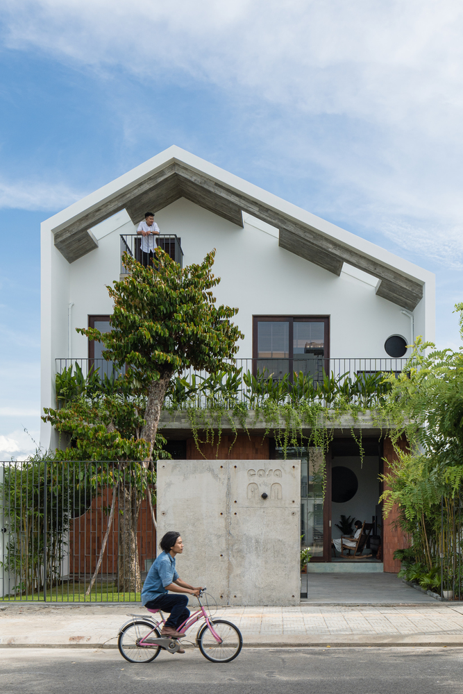 Mặt tiền ngôi nhà 3 tầng gây thiện cảm với kiến trúc hiện đại đơn giản, tông màu trắng xám nhẹ nhàng và thảm thực vật xanh mướt.