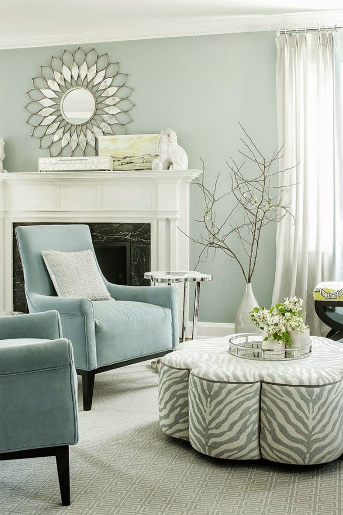 hình ảnh phòng khách với bàn trà hình bông hoa, ghế bành màu xanh ngọc, gương đồng hồ, bàn phụ