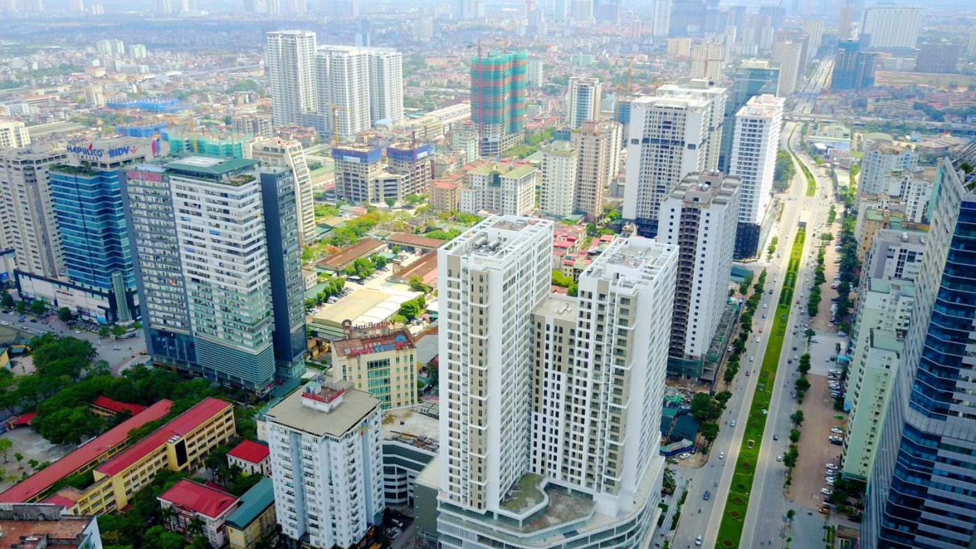 hình ảnh một góc thành phố nhìn từ trên cao với nhiều tòa nhà cao tầng xen kẽ thấp tầng, cây xanh