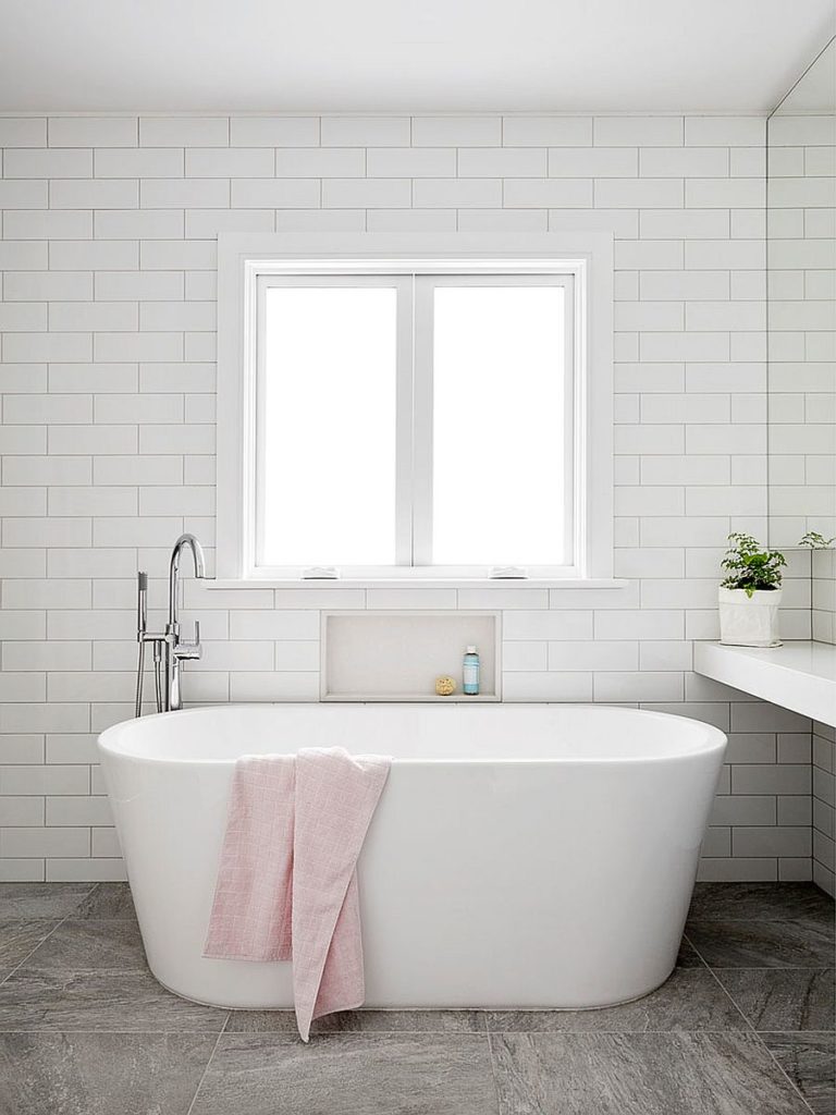Cải tạo phòng tắm tối giản và hiện đại với bồn tắm có chân đế màu trắng.