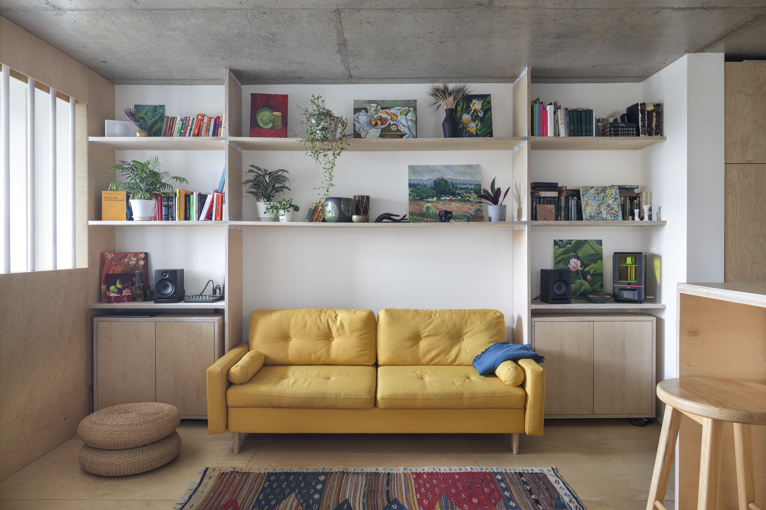 phòng khách căn hộ 50m2 nổi bật với ghế sofa màu vàng, kệ lưu trữ mở gắn tường