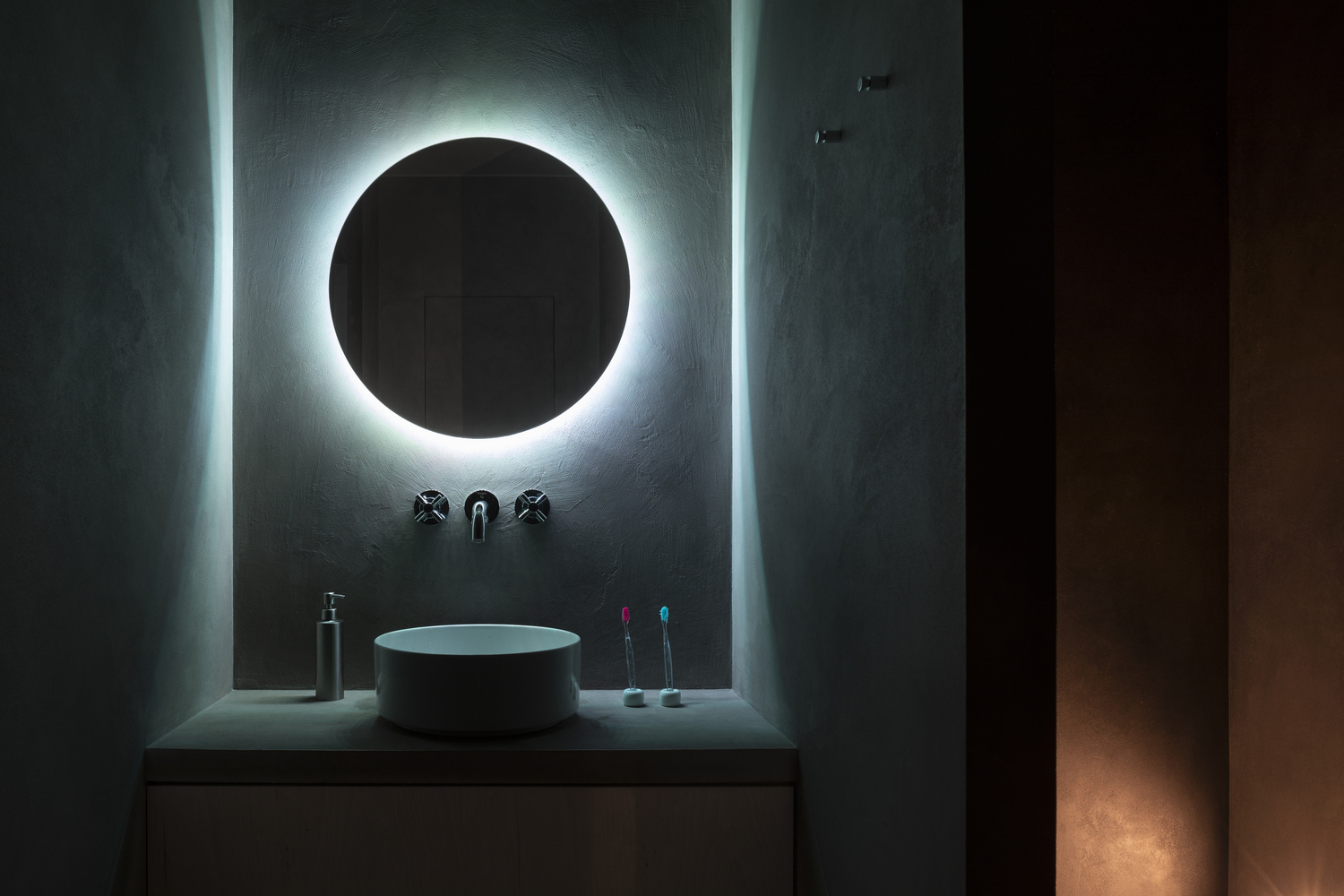 góc phòng tắm với gương tròn gắn đèn LED