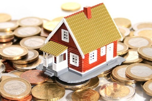 hình ảnh mô hình ngôi nhà mái ngói đặt trên đống tiền xu minh họa cho cổ phiếu bất động sản