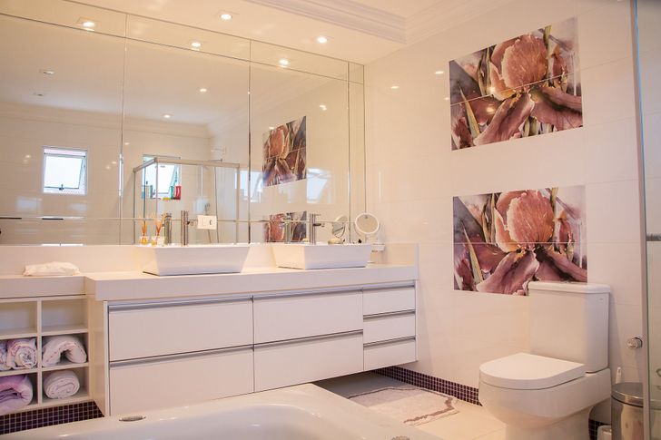 hình ảnh phòng tắm màu trắng chủ đạo với gương lớn gắn tường