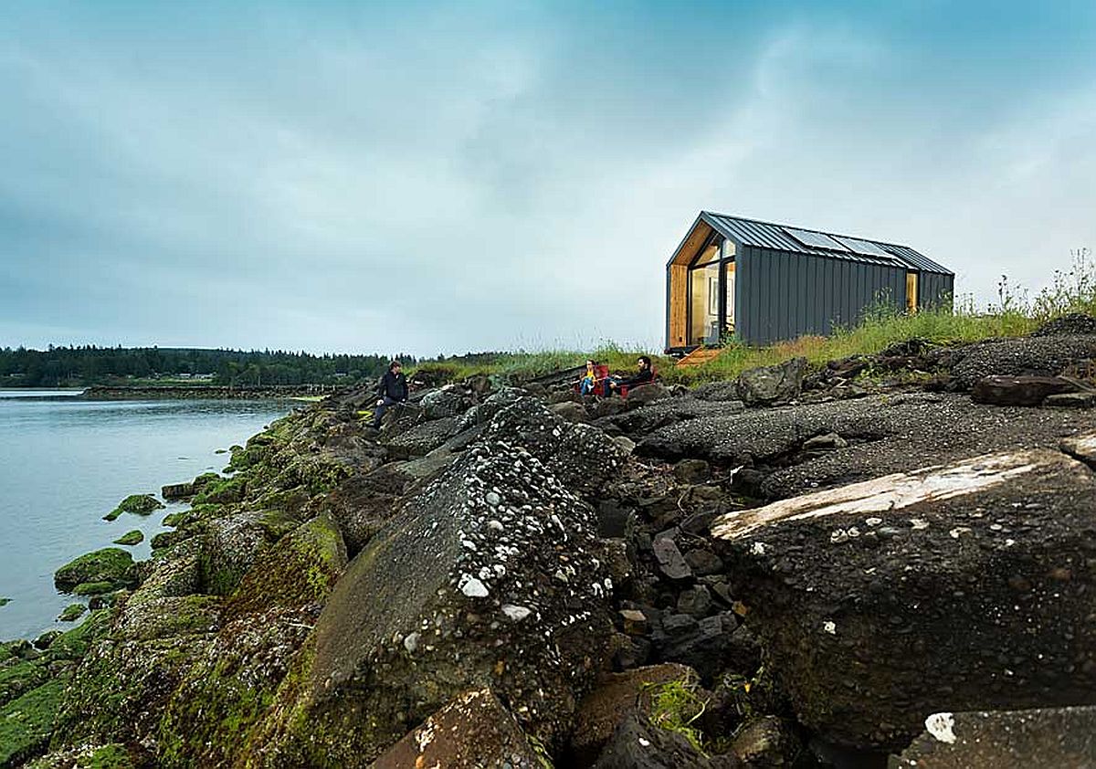 hình ảnh nhà cabin bên mép hồ với đá đen lởm chởm