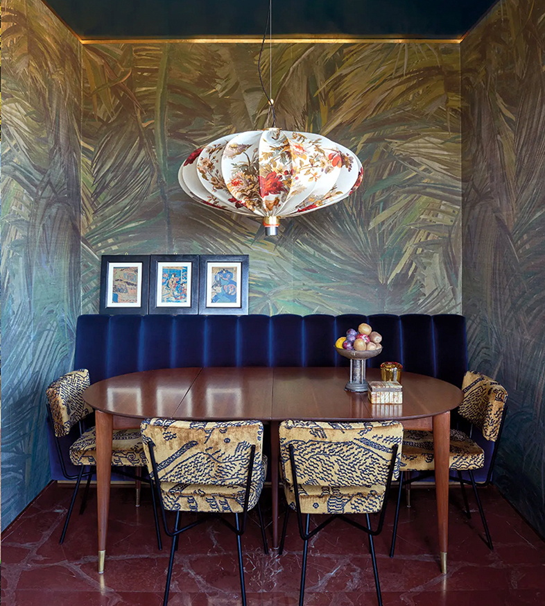 hình ảnh phòng ăn với sàn lát gạch màu đỏ đậm, bàn ăn hình elip, đèn thả dạng đèn lồng, các bức tường gián giấy kiểu sơn mài