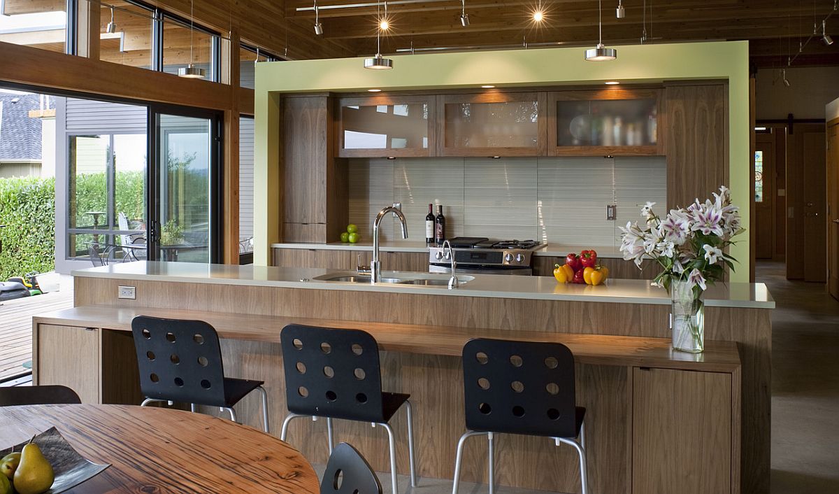 Nhà bếp hiện đại với đảo bếp bằng gỗ tự nhiên, quầy bar ăn sáng tiện dụng cùng một chút màu xanh lá cây nhạt bổ sung bảng màu sinh động, tràn đầy sức sống.