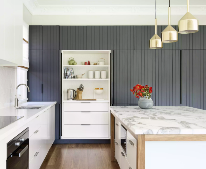 hình ảnh toàn cảnh phòng bếp với tường sơn màu xanh than, đồ nội thất màu trắng, ánh sáng tự nhiên ngập tràn