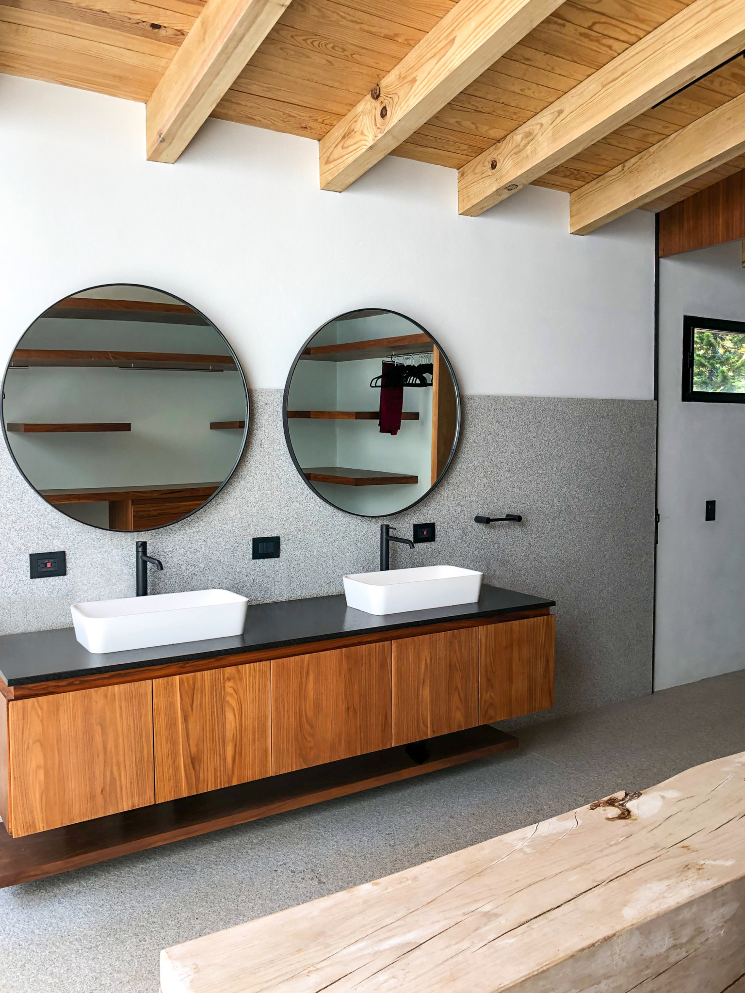 Phòng tắm hiện đại của ngôi nhà thân thiện môi trường với dầm trần bằng gỗ tự nhiên màu sáng ấm áp, tương phản sàn bê tông mộc mạc.