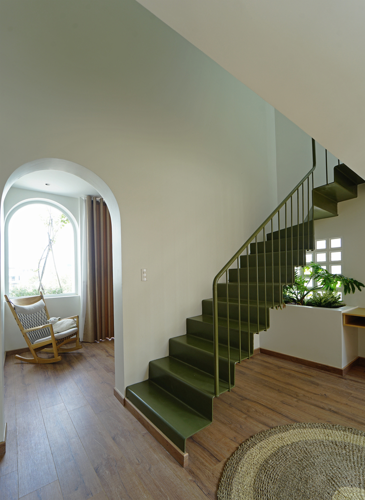 Cầu thang màu xanh lá tạo điểm nhấn màu sắc và kết cấu cho không gian nội thất.
