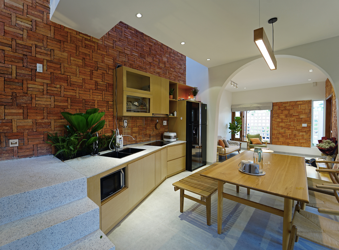 Không gian bếp nấu và phòng ăn ấm cúng hơn với tường gạch không trát.