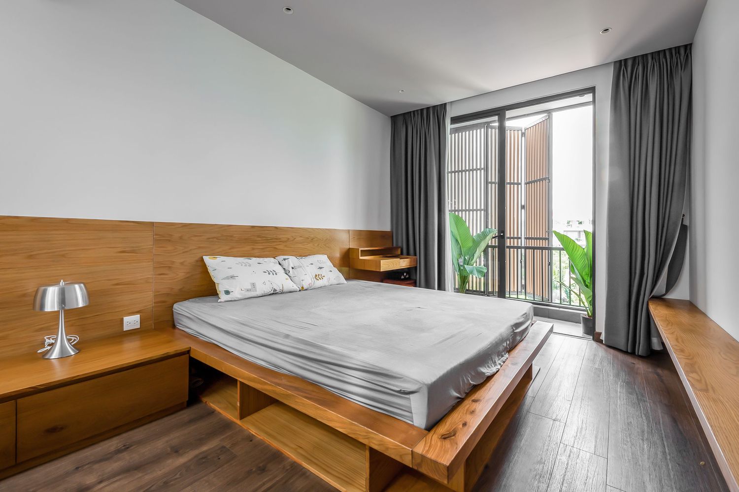 hình ảnh phòng ngủ nhà phố thoáng sáng với tường ốp gỗ màu sáng, cửa kính mở ra khoảng thông tầng