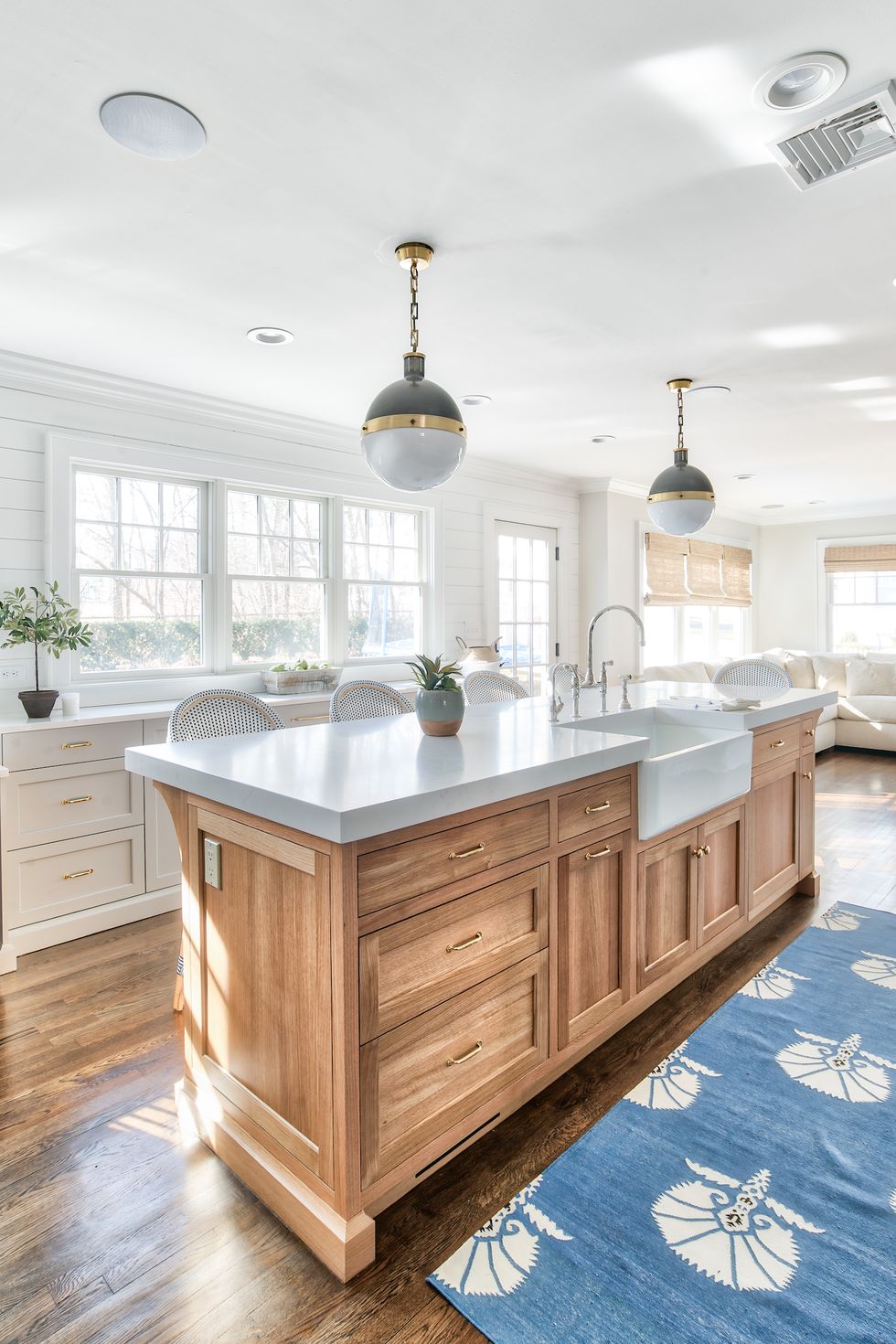 hình ảnh phòng bếp ngập tràn ánh sáng tự nhiên với đảo bếp bằng gỗ ở trung tâm, bề mặt bàn bếp màu xám sang trọng