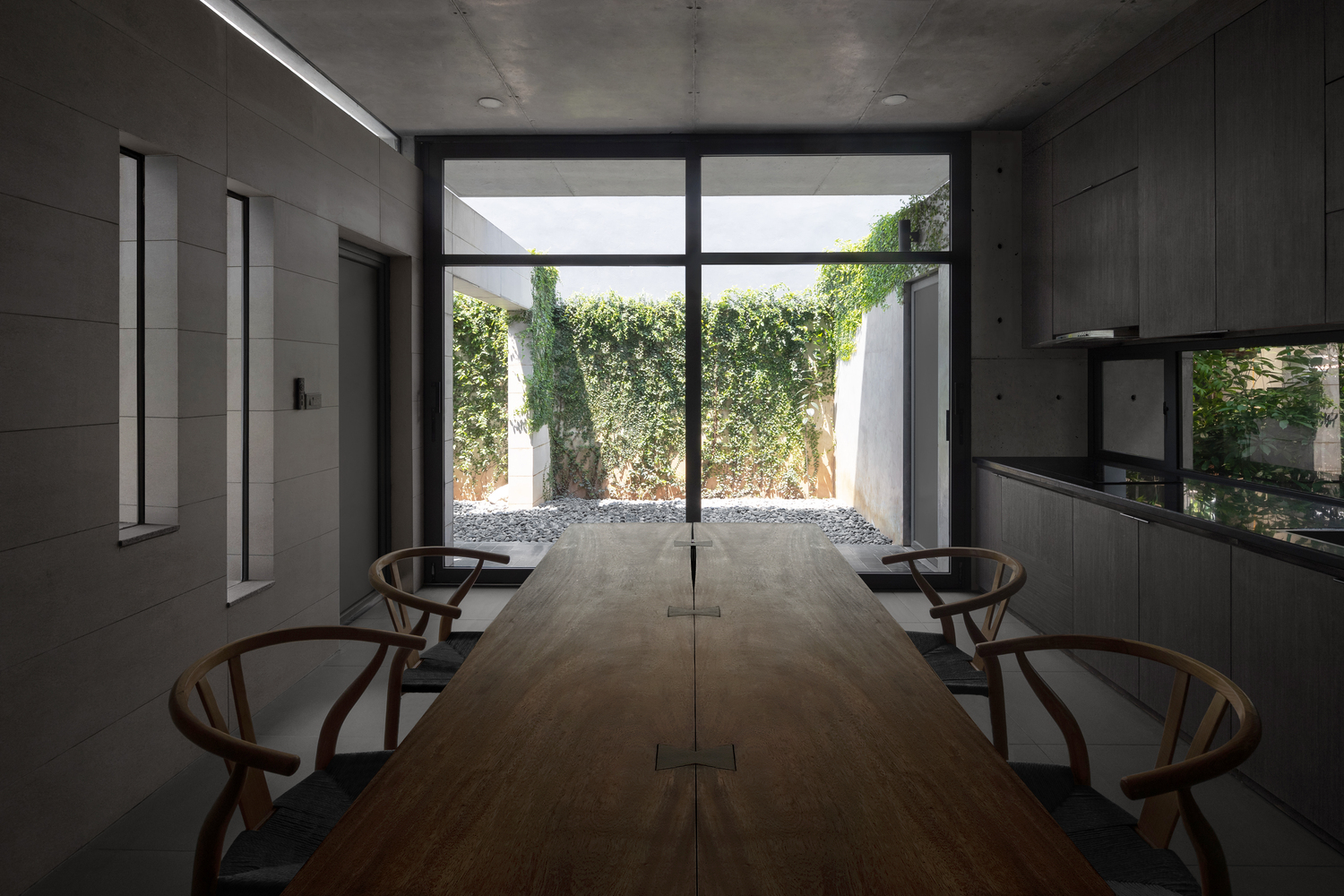 hình ảnh phòng bếp ăn với bàn ghế gỗ mộc mạc, cửa kính lớn mở ra sân vườn