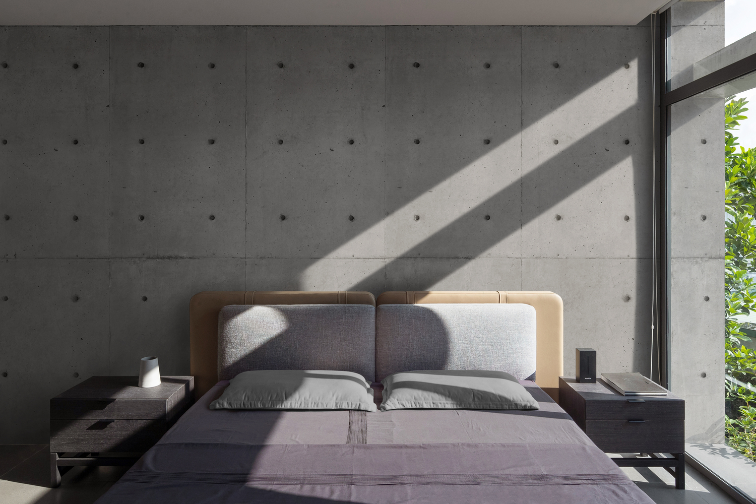 hình ảnh phòng ngủ với tường đầu giường bê tông xám, ga màu tím, cửa kính lớn