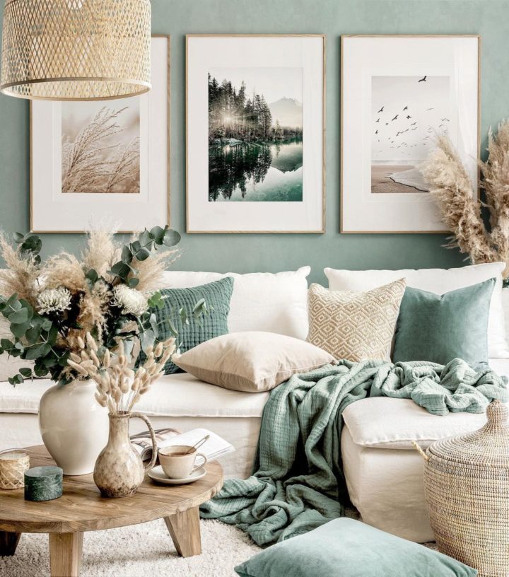 Phòng khách với ghế sofa hiện đại màu kem nổi bật trên bức tường màu xanh lá và "phòng" trưng bày nghệ thuật trên tường.