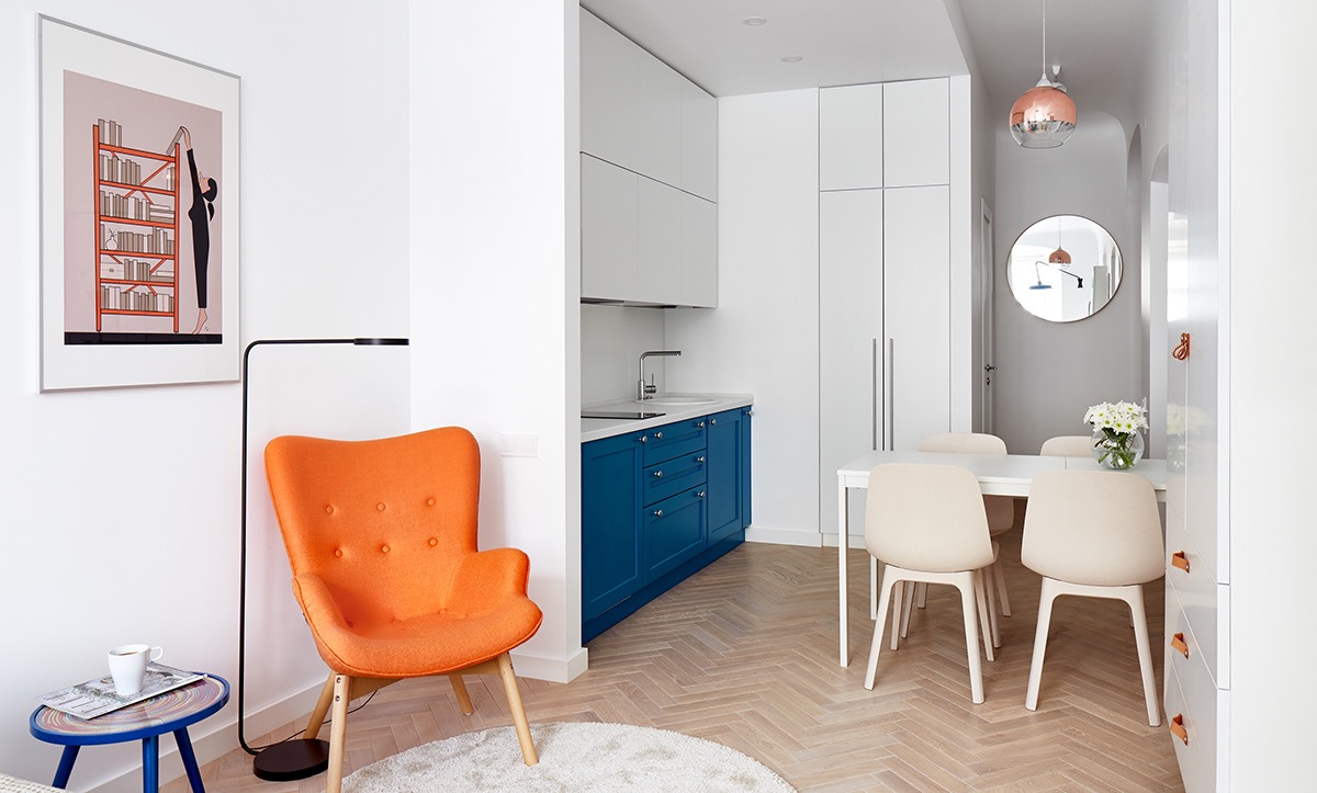 Chiếc ghế màu cam tươi sáng đóng vai trò là điểm nhấn trực quan giữa phòng ngủ, phòng khách và khu vực ăn uống. 