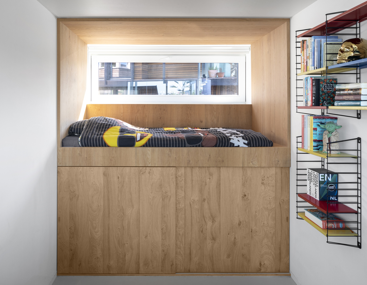 hình ảnh góc phòng ngủ với khối hộp gỗ màu sáng, cạnh đó là giá kệ lưu trữ