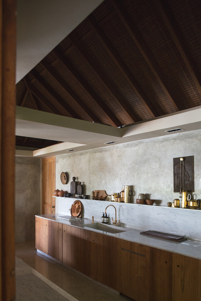 hình ảnh góc phòng bếp với mái gỗ dốc, kệ mở gắn tường, bồn rửa đơn giản
