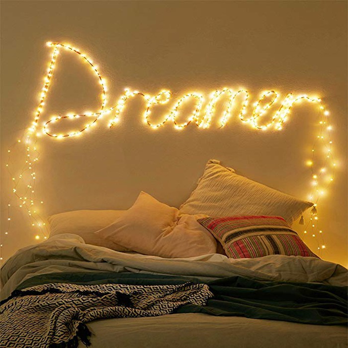 hình ảnh phòng ngủ với giường đôi, tường đầu giường gắn dòng chữ Dream kết hợp đèn LED ánh sáng vàng dịu nhẹ