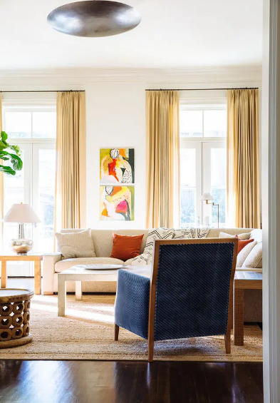 hình ảnh minh họa cho trang trí nhà mùa đông, phòng khách với tường trắng, ghế sofa màu sữa, ghế tựa màu xanh nước biển, rèm cửa sổ màu vàng dáng dài
