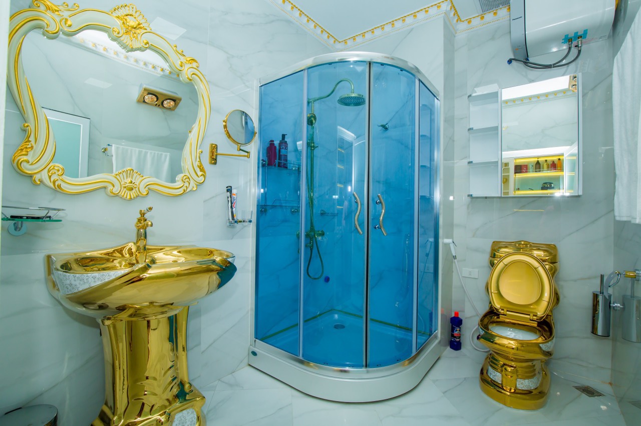 hình ảnh phòng tắm với bồn cầu, bồn rửa mặt đều dát vàng