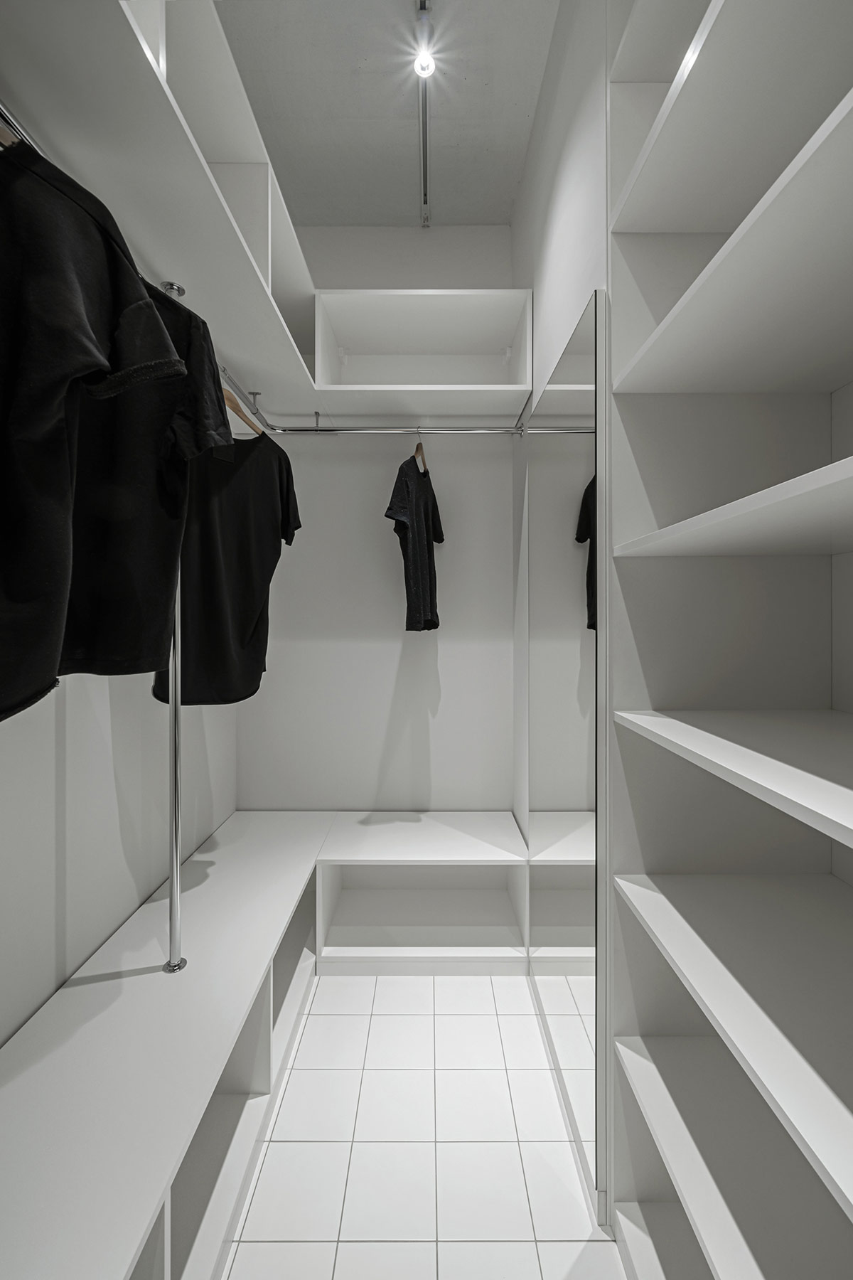 hình ảnh bên trong tủ quần áo với các ngăn kệ lưu trữ màu trắng của căn hộ nhỏ