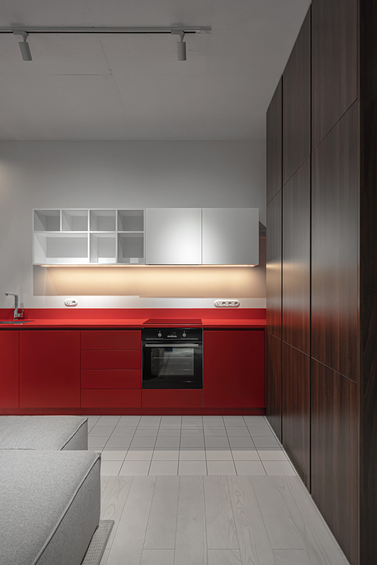 Kiến trúc sư khéo léo bố trí tủ bếp trên màu trắng, giúp cân bằng với hệ tủ dưới màu đỏ, đảm bảo tính thẩm mỹ tổng thể.
