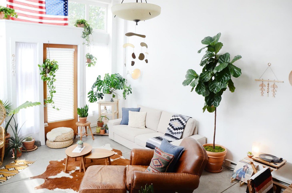 hình ảnh phòng khách nổi bật với ghế sofa màu vàng da bò, cây xanh trang trí đặt rải rác xung quanh phòng