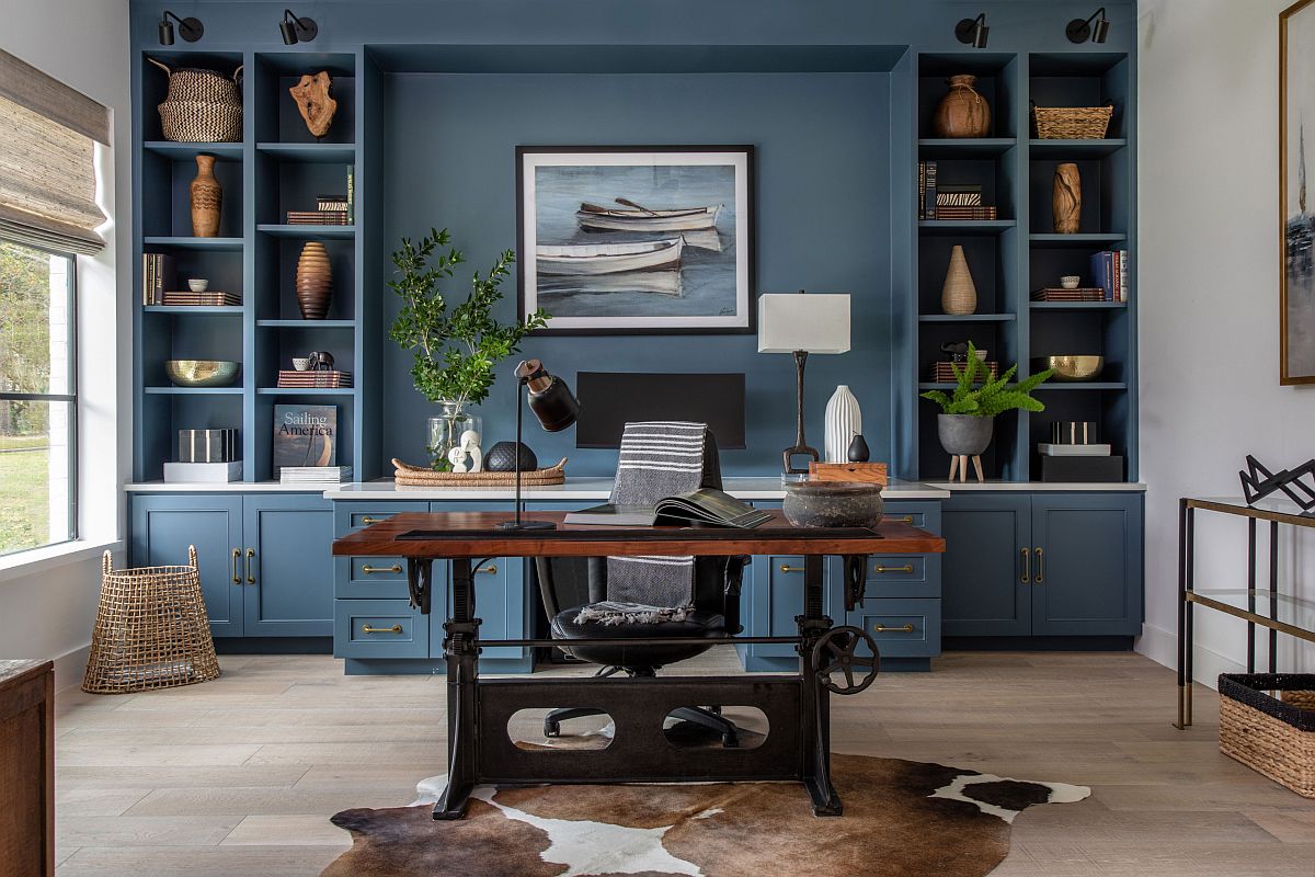 hình ảnh phòng làm việc tại nhà với bàn gỗ, tủ kệ phía sau màu xanh lam đậm