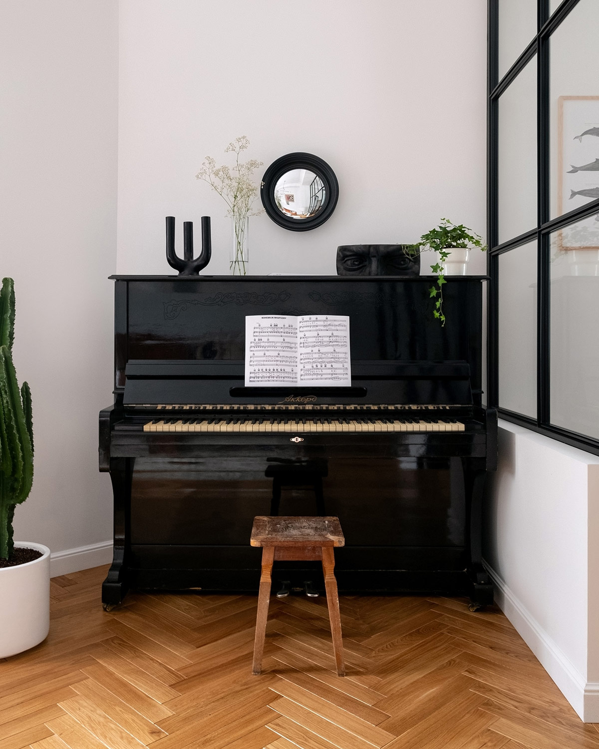Không gian góc cạnh khó xử lý nhất trong phòng khách lại là nơi hoàn hảo cho một cây đàn piano cũ và một chiếc ghế đẩu mộc mạc. Gương nhỏ treo tường trang trí tạo thêm điểm sáng cho góc nhà.