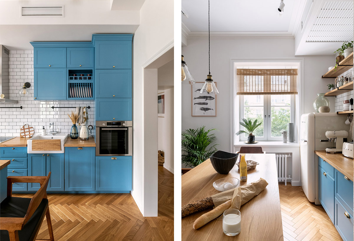 hình ảnh phòng bếp căn hộ 74m2 với tường ốp gạch trắng, tủ bếp màu xanh lam, cây xanh trang trí
