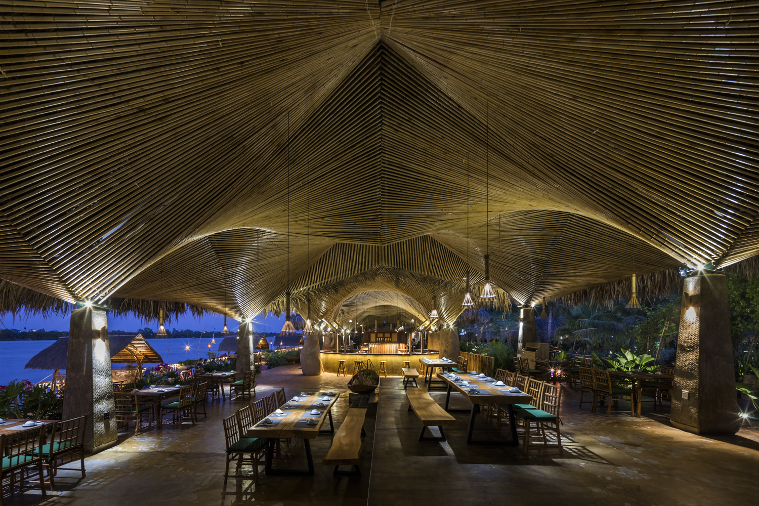 khung cảnh nhà hàng ven sông về đêm với ánh đèn vàng ấm áp