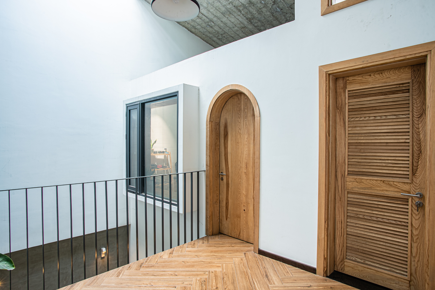 hành lang nhà ống dẫn vào các phòng riêng với cửa gỗ tự nhiên, cửa vòm mềm mại