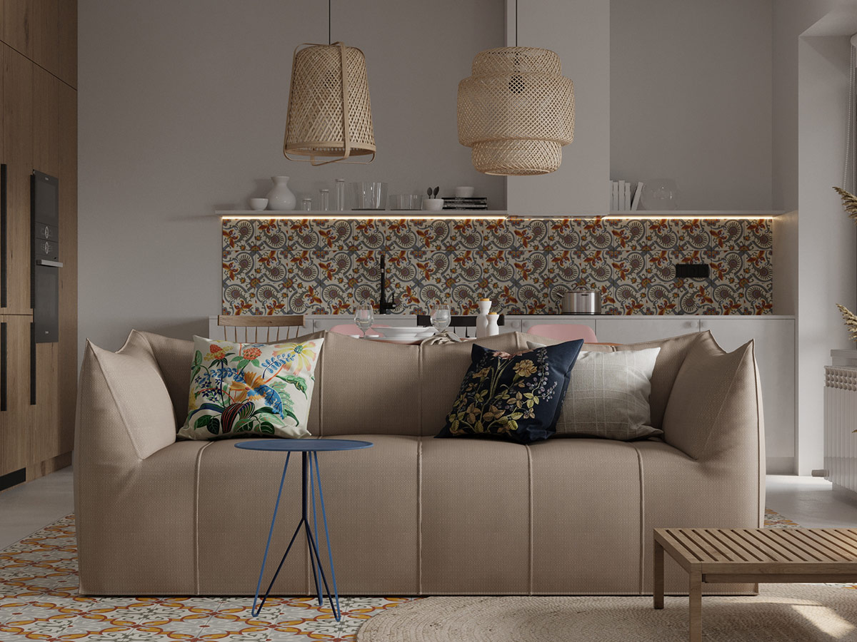 Trong phòng khách căn hộ 95m2, ghế sofa màu be ấm áp, làm nền cho gối tựa họa tiết nhiệt đới thêm phần nổi bật. Gạch lát màu cam tạo sự liên kết chặt chẽ với tường chắn bếp.