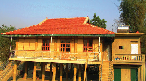Mẫu nhà sàn nhỏ với mái lợp ngói đỏ, kết cấu bằng gỗ kết hợp bê tông chắc chắn.