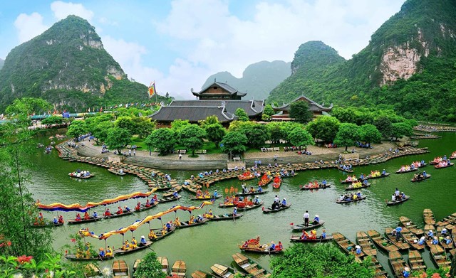 hình ảnh một khu du lịch sông nước ở Ninh Bình với đền chùa trung tâm, thuyền ghe tấp nập, núi non xanh ngát