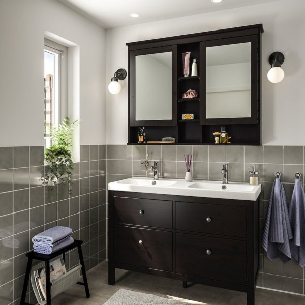 hình ảnh phòng tắm với gạch ốp tường màu xám, bồn rửa sứ trắng, gương với đèn tròn màu trắng đối xứng hai bên, cửa sổ kính