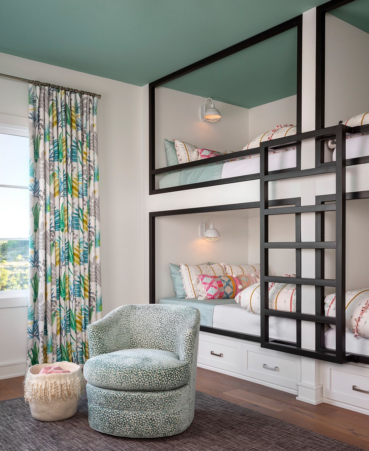 hình ảnh phòng ngủ trẻ em với giường tầng khung đen trắng, rèm cửa hoa văn nhiệt đới, ghế bành thư giãn, trần sơn màu xanh ngọc